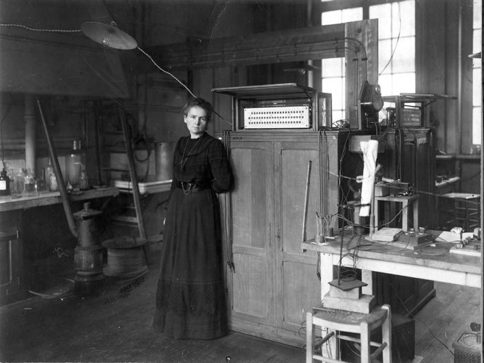Svartvit, gammal bild på en kvinna i ett laboratorium.
